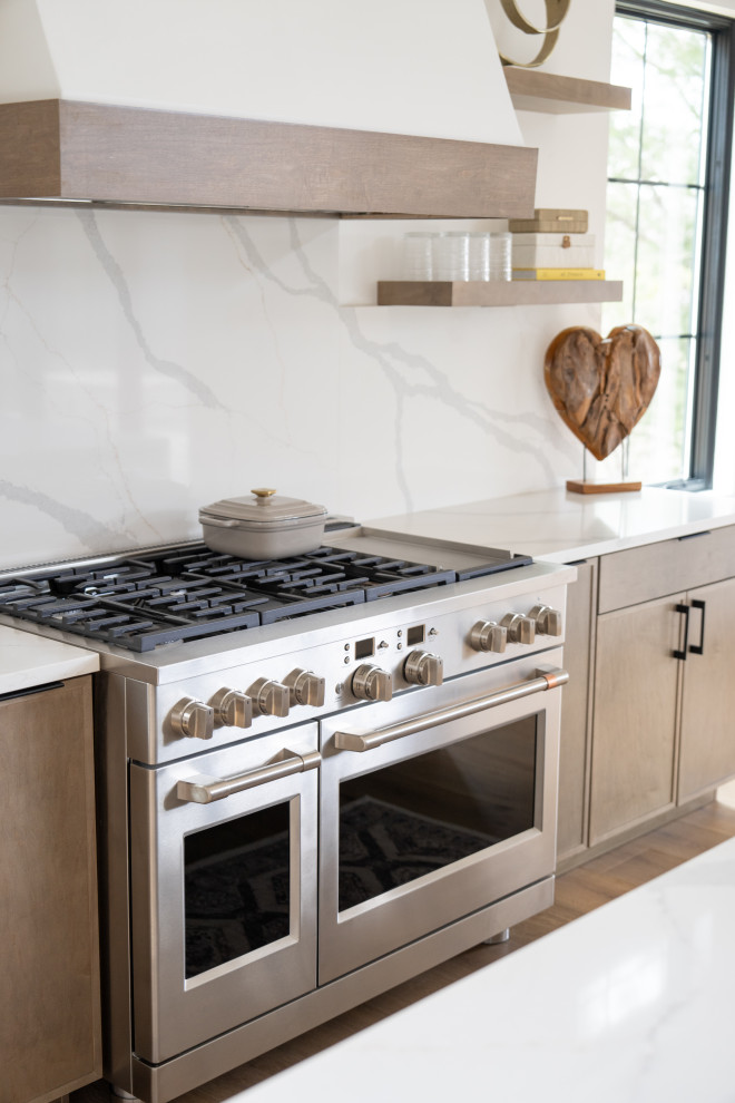 Transitional medium tone wood floor kitchen photo with quartzite countertops, quartz backsplash and an island