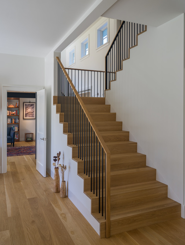 This is an example of a contemporary wood u-shaped staircase in Boston with wood risers and mixed railing.