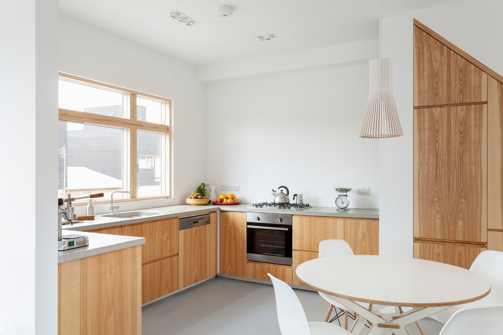 Inspiration for a mid-sized contemporary u-shaped eat-in kitchen in London with an integrated sink, flat-panel cabinets, medium wood cabinets, panelled appliances and no island.