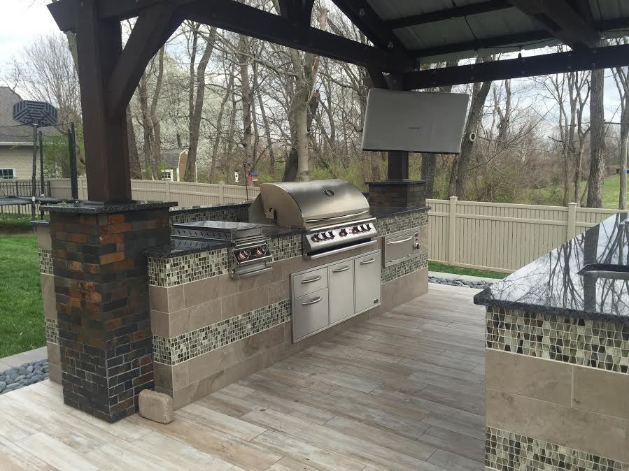 Photo of a mid-sized traditional backyard patio in St Louis with an outdoor kitchen, decking and a gazebo/cabana.