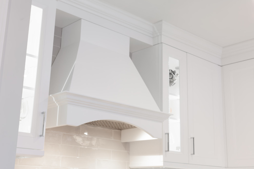 Enclosed kitchen - large transitional l-shaped medium tone wood floor and brown floor enclosed kitchen idea with an undermount sink, recessed-panel cabinets, white cabinets, quartz countertops, gray backsplash, ceramic backsplash, stainless steel appliances, an island and white countertops