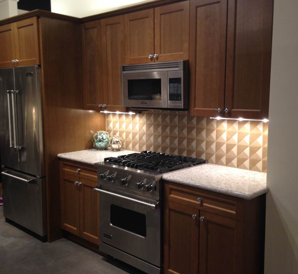 Example of a mid-sized transitional single-wall concrete floor kitchen design with quartzite countertops, multicolored backsplash, stone tile backsplash, stainless steel appliances, recessed-panel cabinets and dark wood cabinets