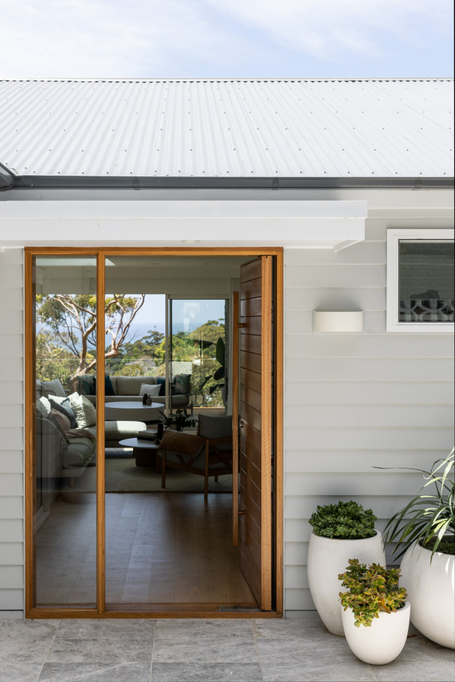 Photo of a contemporary front door in Sydney with grey walls, limestone floors, a single front door and a medium wood front door.