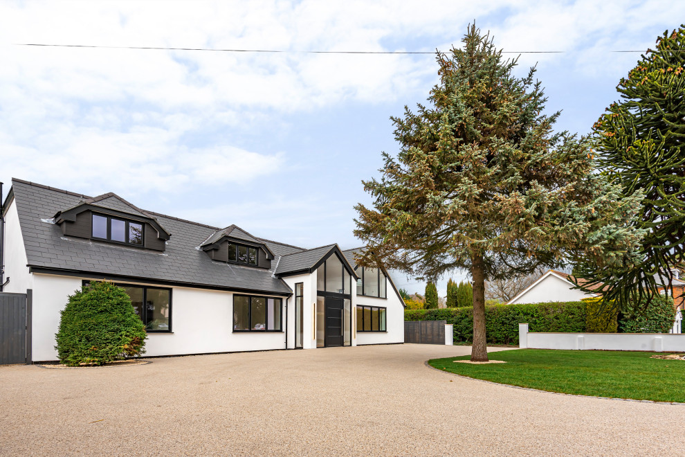 Großes, Zweistöckiges Modernes Einfamilienhaus mit Putzfassade, weißer Fassadenfarbe, Satteldach, Ziegeldach und grauem Dach in Surrey