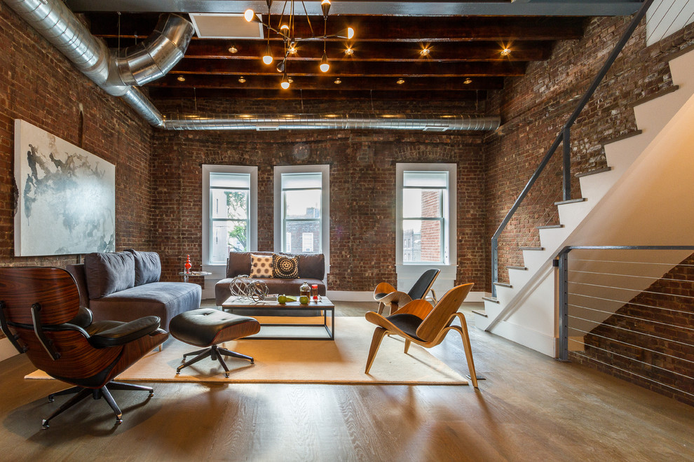 Mid-sized industrial formal open concept living room in New York with brown walls, light hardwood floors, no tv, no fireplace and brown floor.