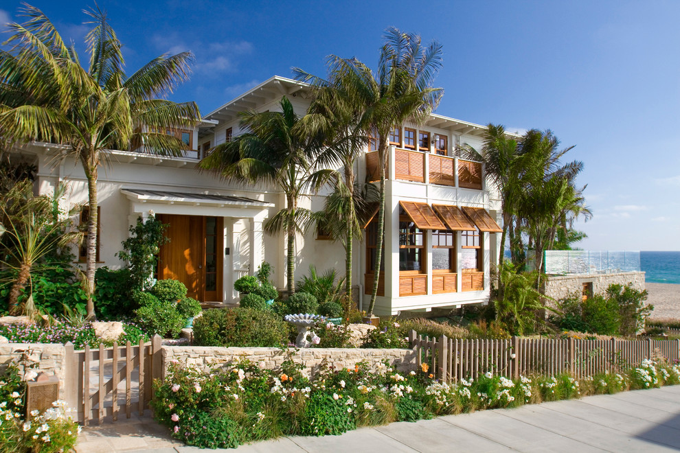 This is an example of a tropical two-storey stucco white exterior in Los Angeles with a flat roof.