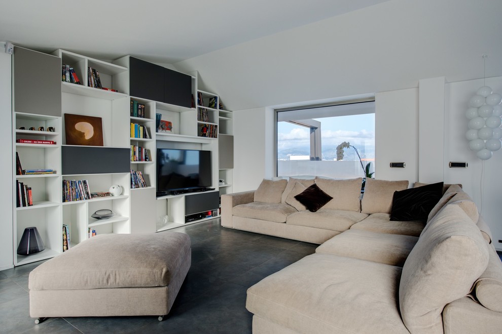 Photo of a large contemporary family room in Catania-Palermo with a library, white walls, concrete floors, no fireplace and a freestanding tv.