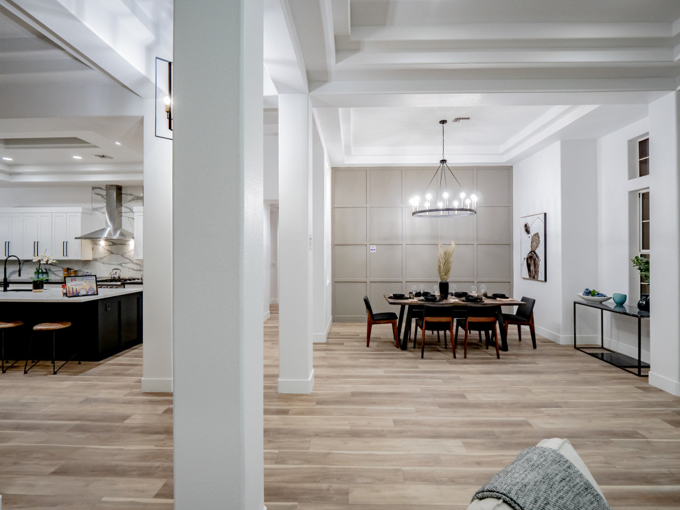 Foto di una grande sala da pranzo aperta verso la cucina minimal con pareti bianche, pavimento marrone, soffitto ribassato, pavimento in vinile e nessun camino