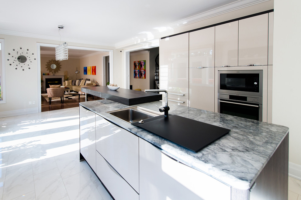 Inspiration for a mid-sized contemporary u-shaped kitchen remodel in Toronto with flat-panel cabinets, quartz countertops, paneled appliances and an island