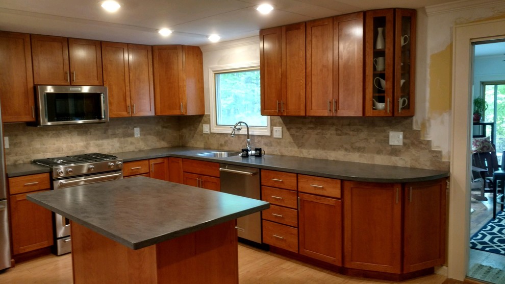 Minimalist kitchen photo in New York with an undermount sink, shaker cabinets, solid surface countertops, beige backsplash, ceramic backsplash, stainless steel appliances, an island and gray countertops
