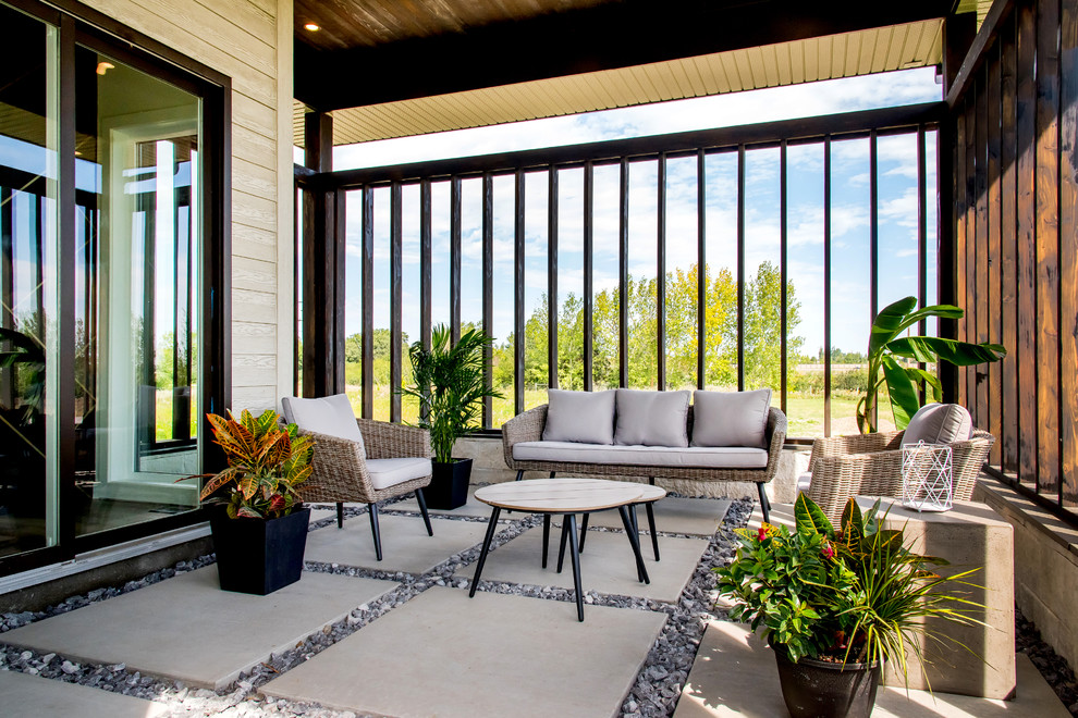 Transitional concrete paver porch container garden idea with a roof extension