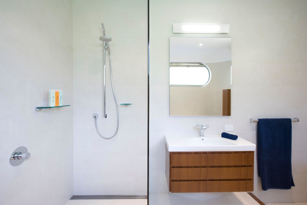 Large contemporary master bathroom in Melbourne with furniture-like cabinets, medium wood cabinets, white tile, porcelain tile, an open shower, an integrated sink, white walls and porcelain floors.
