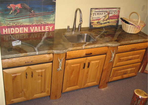 Medium tone wood floor kitchen photo with light wood cabinets, concrete countertops and stainless steel appliances