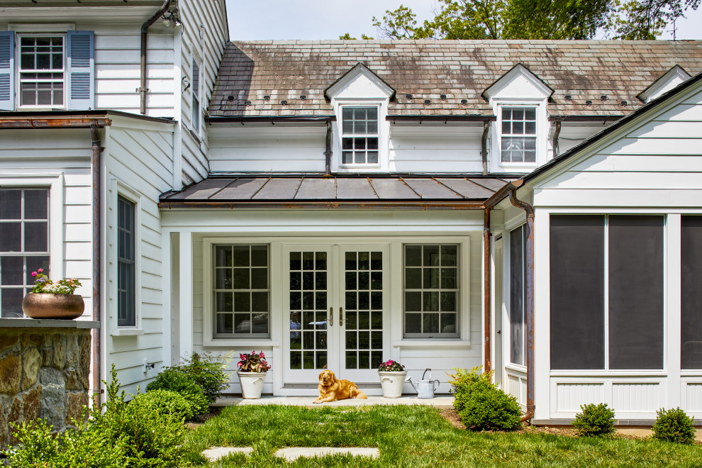 Mid-sized elegant white two-story wood and clapboard house exterior photo in DC Metro with a shed roof, a metal roof and a brown roof
