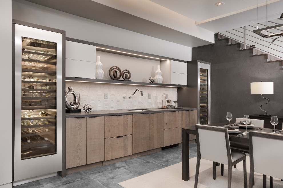 Photo of a mid-sized contemporary single-wall wet bar in Las Vegas with an undermount sink, flat-panel cabinets, medium wood cabinets, granite benchtops, white splashback, ceramic splashback, porcelain floors, grey floor and grey benchtop.