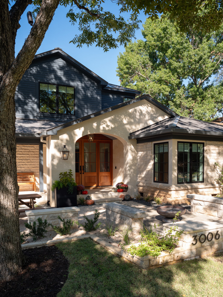 Transitional limestone floor and vaulted ceiling vestibule photo in Austin with a medium wood front door