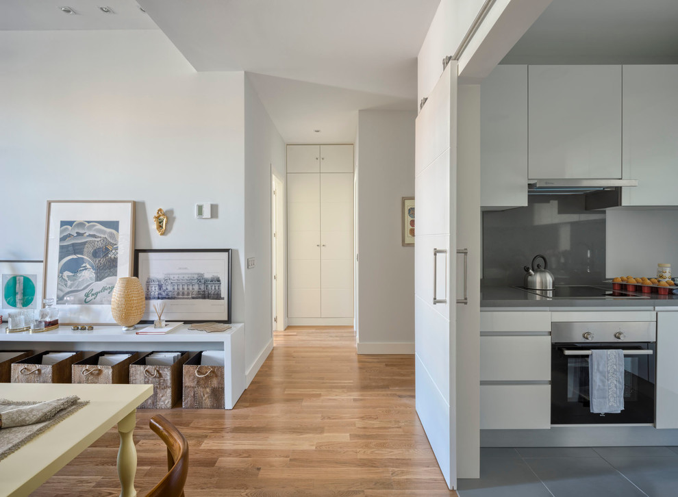 This is an example of a mid-sized eclectic hallway in Malaga with white walls and medium hardwood floors.