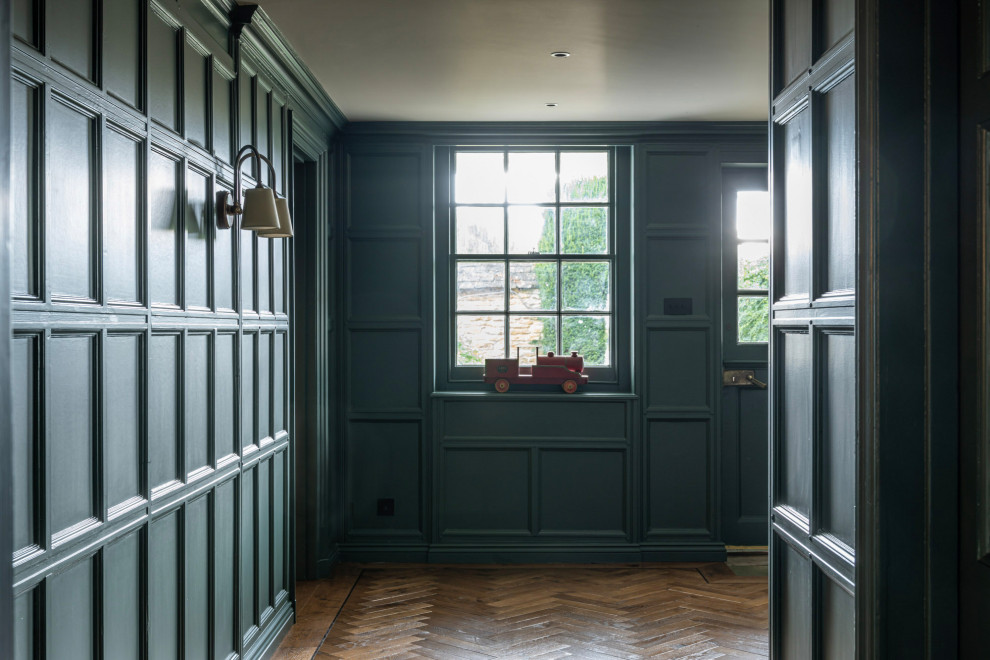 Foto de recibidores y pasillos clásicos renovados con paredes azules, suelo de madera en tonos medios y panelado