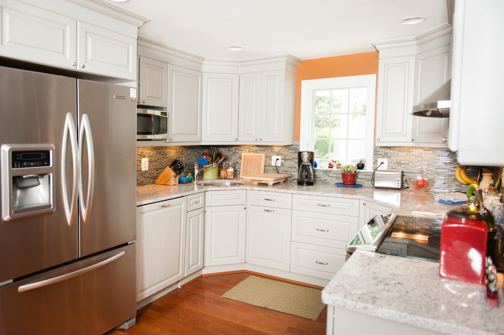 Inspiration for a mid-sized transitional u-shaped medium tone wood floor eat-in kitchen remodel in DC Metro with an undermount sink, raised-panel cabinets, white cabinets, quartzite countertops, multicolored backsplash, matchstick tile backsplash, stainless steel appliances and no island