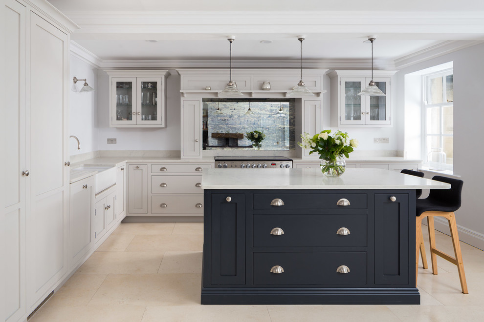 This is an example of a large traditional l-shaped eat-in kitchen in Other with shaker cabinets, granite benchtops, metallic splashback, glass sheet splashback, stainless steel appliances, limestone floors, with island, beige floor, white benchtop and a farmhouse sink.