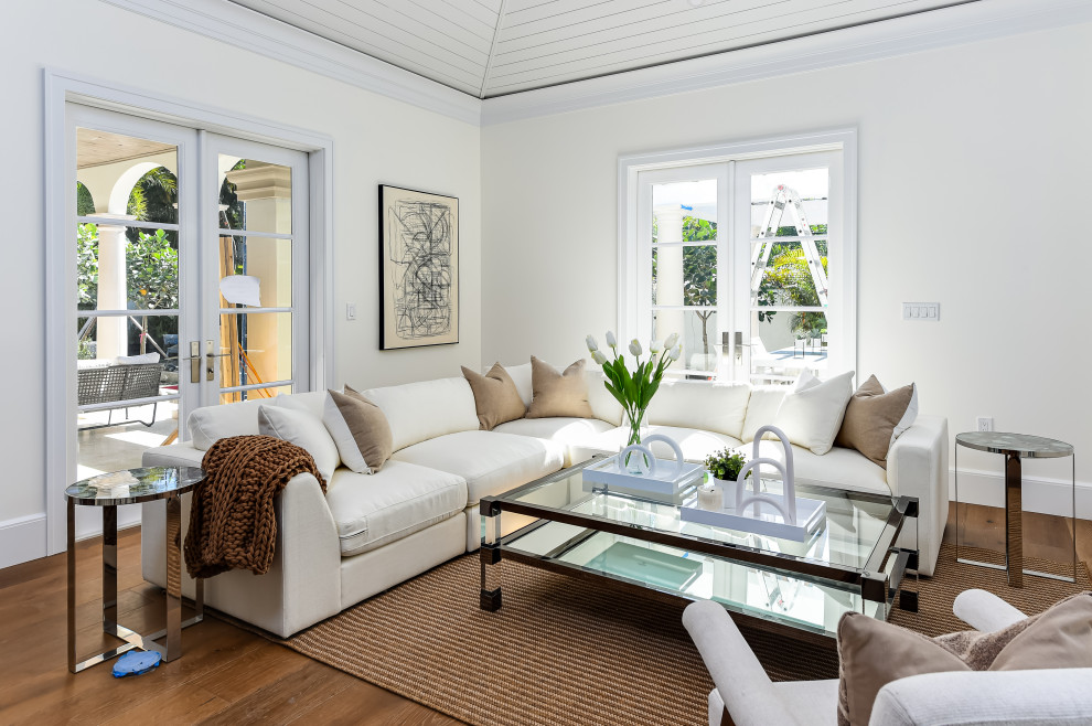 Large transitional open concept dark wood floor, brown floor and coffered ceiling family room photo in Miami with white walls