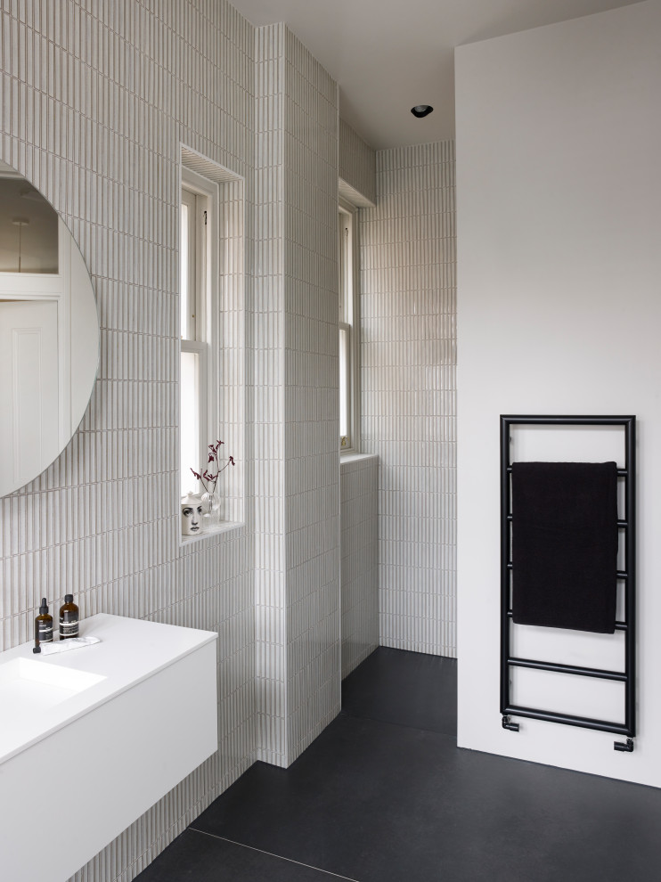 Inspiration for a mid-sized contemporary kids bathroom in London with a freestanding tub, an open shower, a wall-mount toilet, white tile, porcelain tile, beige walls, slate floors, a wall-mount sink, grey floor and an open shower.