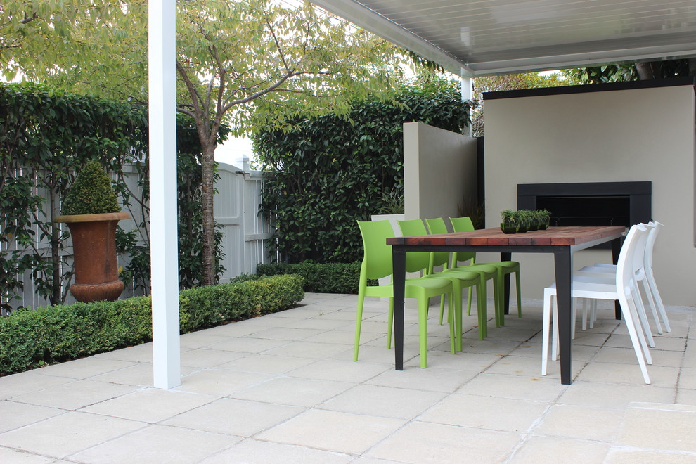 Photo of a mid-sized contemporary backyard patio in Christchurch with a fire feature and a pergola.