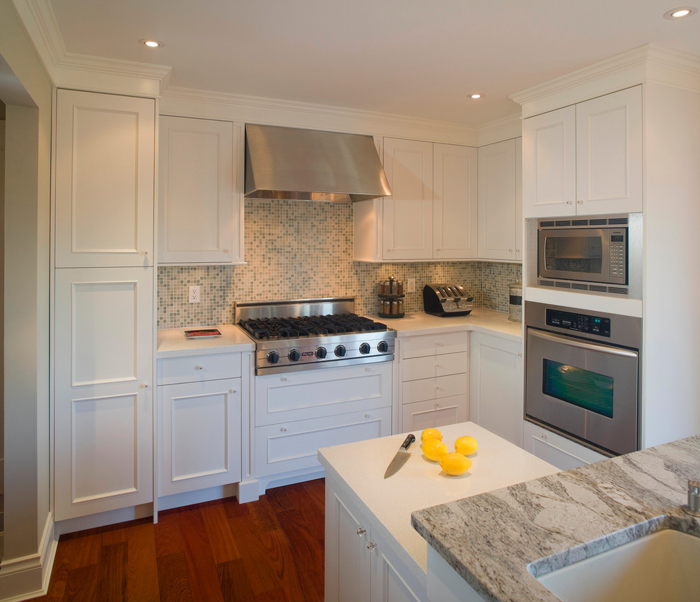 This is an example of a traditional kitchen in Vancouver with mosaic tile splashback, recessed-panel cabinets, stainless steel appliances, multi-coloured splashback and white cabinets.