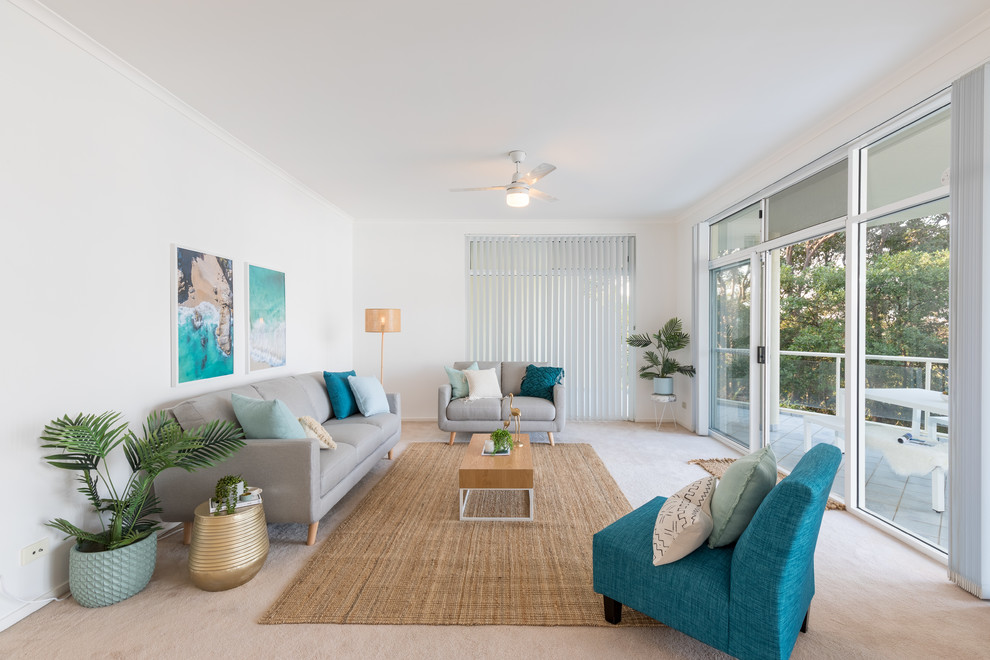 Mid-sized beach style living room in Other with white walls, carpet and beige floor.