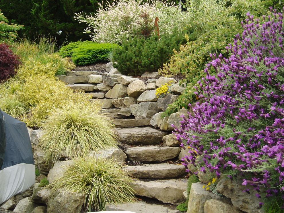 Photo of a mid-sized rustic full sun side yard stone landscaping in Portland.