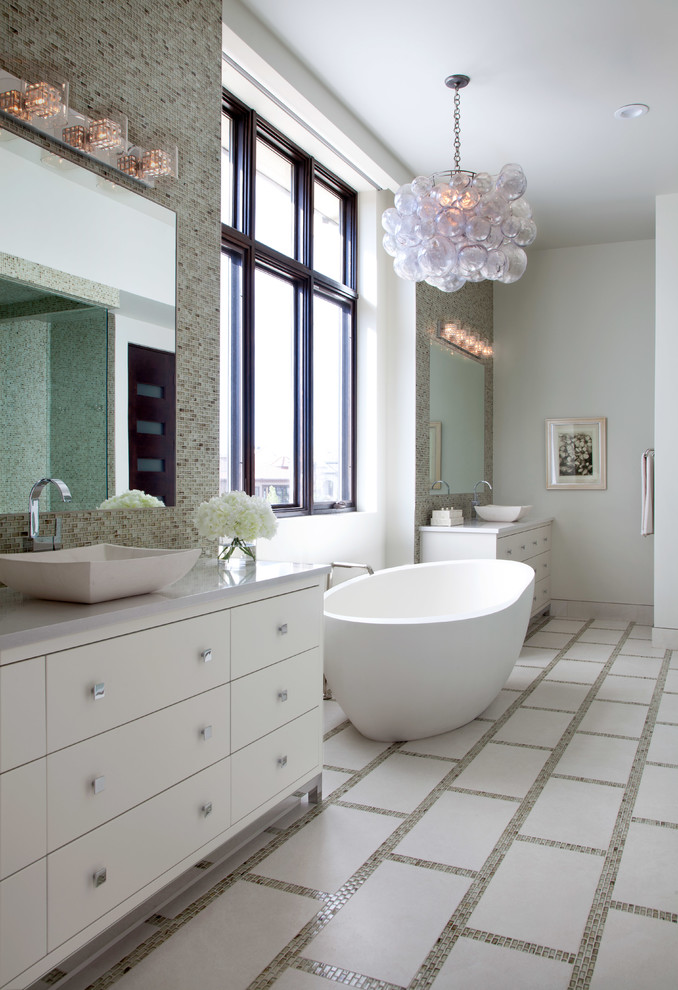 This is an example of a large transitional master bathroom in Denver with a vessel sink, flat-panel cabinets, white cabinets, quartzite benchtops, a freestanding tub, a double shower, a one-piece toilet, beige tile, mosaic tile, white walls and mosaic tile floors.