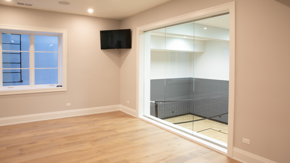 Esempio di un grande soggiorno minimalista aperto con pareti beige, parquet chiaro, porta TV ad angolo e pavimento beige