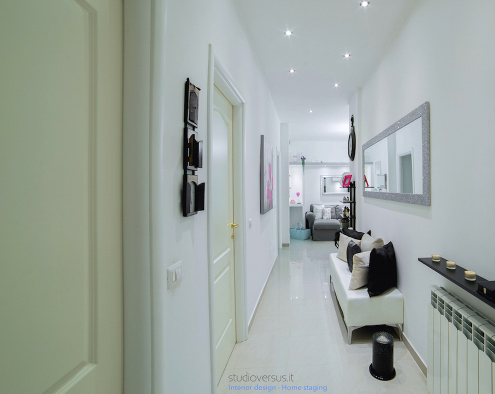 This is an example of a small eclectic hallway in Rome with white walls and porcelain floors.