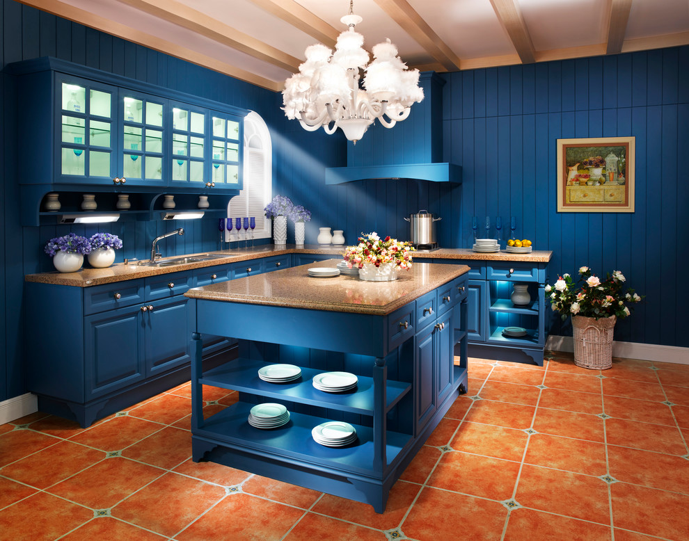 Large country galley eat-in kitchen in Los Angeles with a double-bowl sink, blue cabinets, granite benchtops, blue splashback, stainless steel appliances, terra-cotta floors and with island.