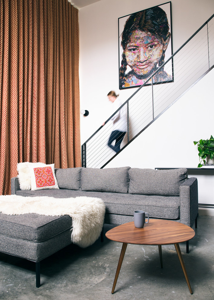 This is an example of a small contemporary formal loft-style living room in San Francisco with white walls, concrete floors and grey floor.