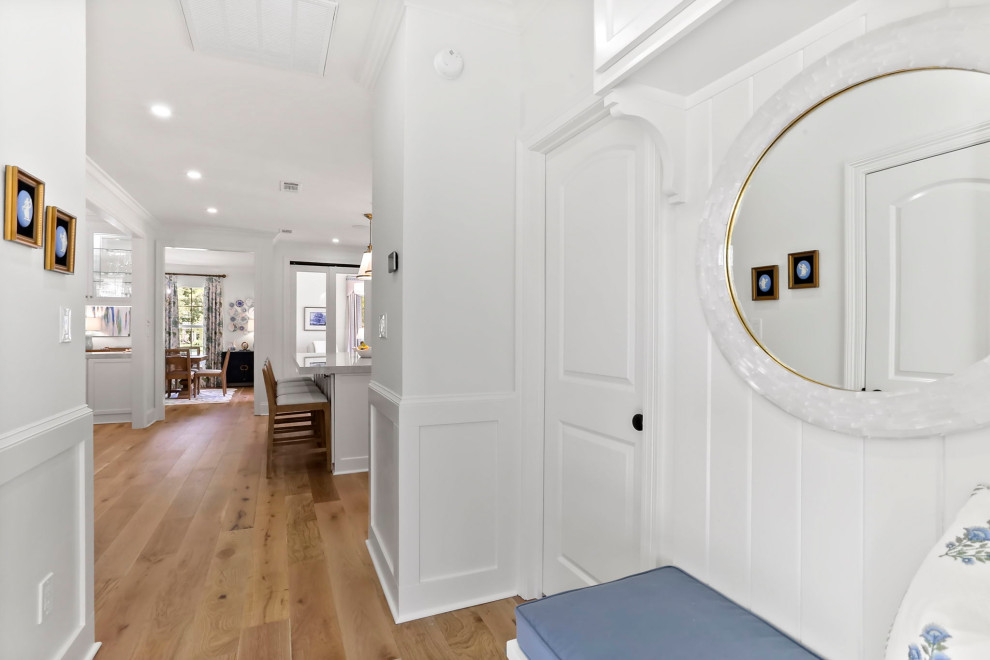 Mudroom - mid-sized transitional light wood floor and brown floor mudroom idea in New Orleans with white walls