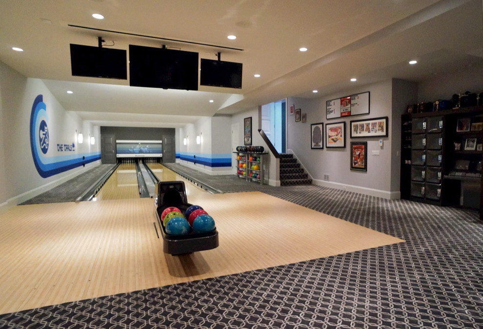 This is an example of a large transitional home gym in Chicago with grey walls and light hardwood floors.