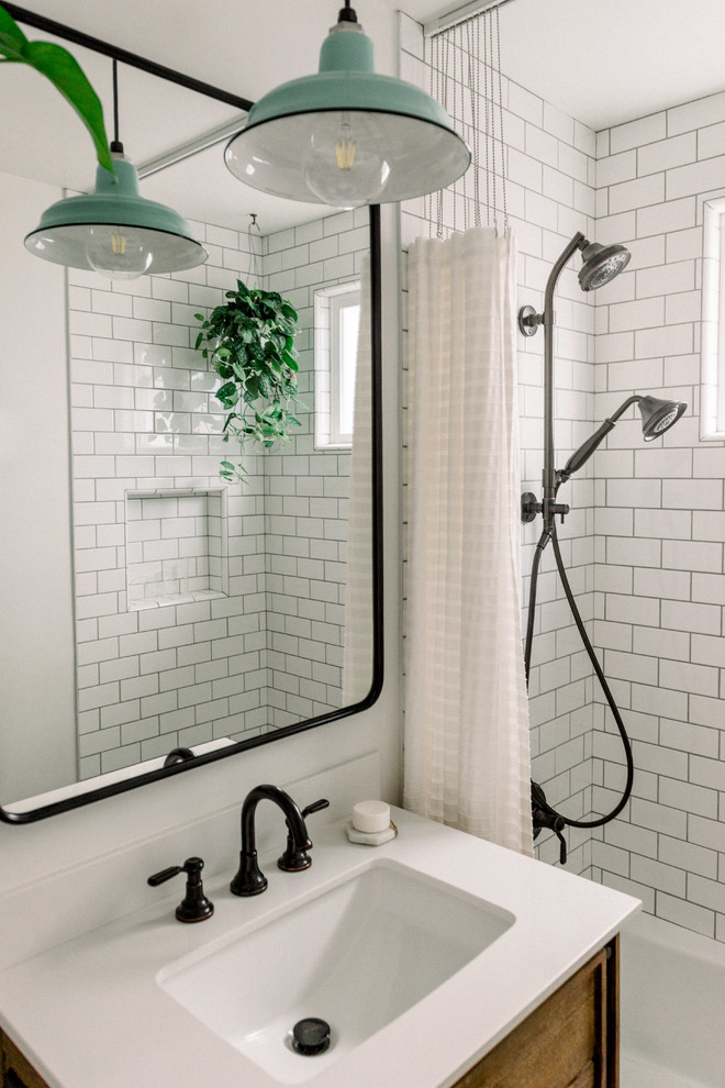 Small country kids bathroom in San Diego with flat-panel cabinets, medium wood cabinets, a corner tub, an alcove shower, a two-piece toilet, white tile, subway tile, white walls, porcelain floors, a console sink, engineered quartz benchtops, black floor, a shower curtain and white benchtops.