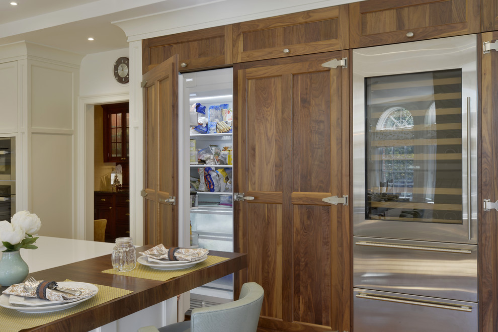 Open concept kitchen - large transitional l-shaped medium tone wood floor and brown floor open concept kitchen idea in New York with an undermount sink, shaker cabinets, white cabinets, wood countertops, white backsplash, marble backsplash, paneled appliances and an island
