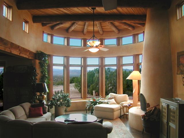 Mid-sized formal open concept living room in Albuquerque with beige walls, a standard fireplace, a plaster fireplace surround, concrete floors, no tv and grey floor.