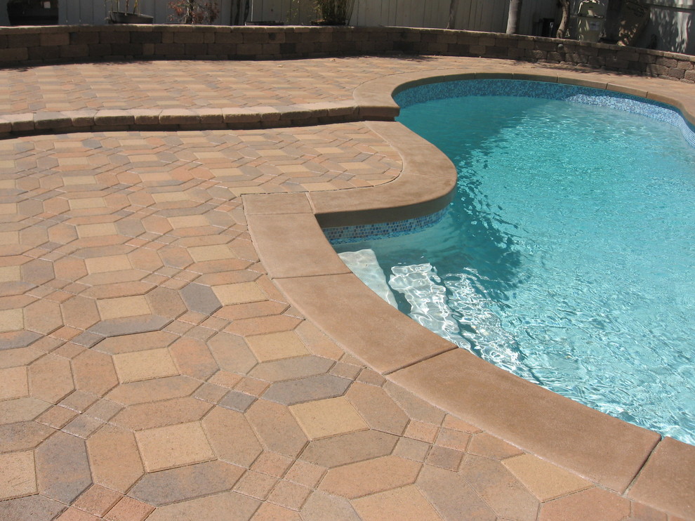 Mid-sized backyard concrete paver pool house photo in Orange County