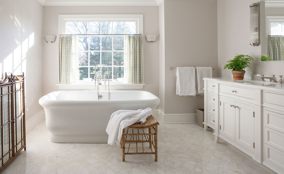 Photo of a large traditional master bathroom in New York with an undermount sink, recessed-panel cabinets, white cabinets, a freestanding tub, grey walls, an open shower, a one-piece toilet, white tile, stone slab, terra-cotta floors, solid surface benchtops, white floor and white benchtops.