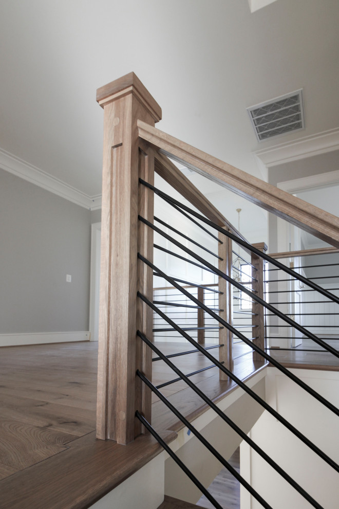 Aménagement d'un grand escalier flottant rétro avec des marches en bois, des contremarches en bois et un garde-corps en matériaux mixtes.