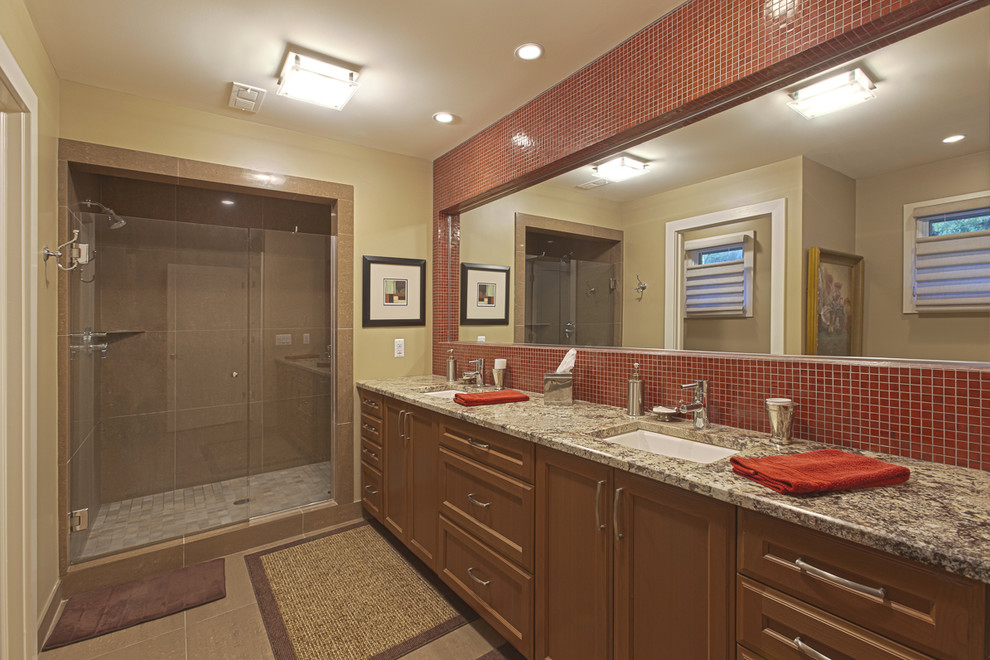 This is an example of a large traditional bathroom in Detroit with an undermount sink, medium wood cabinets, granite benchtops, a corner shower, red tile, beige walls and terra-cotta floors.