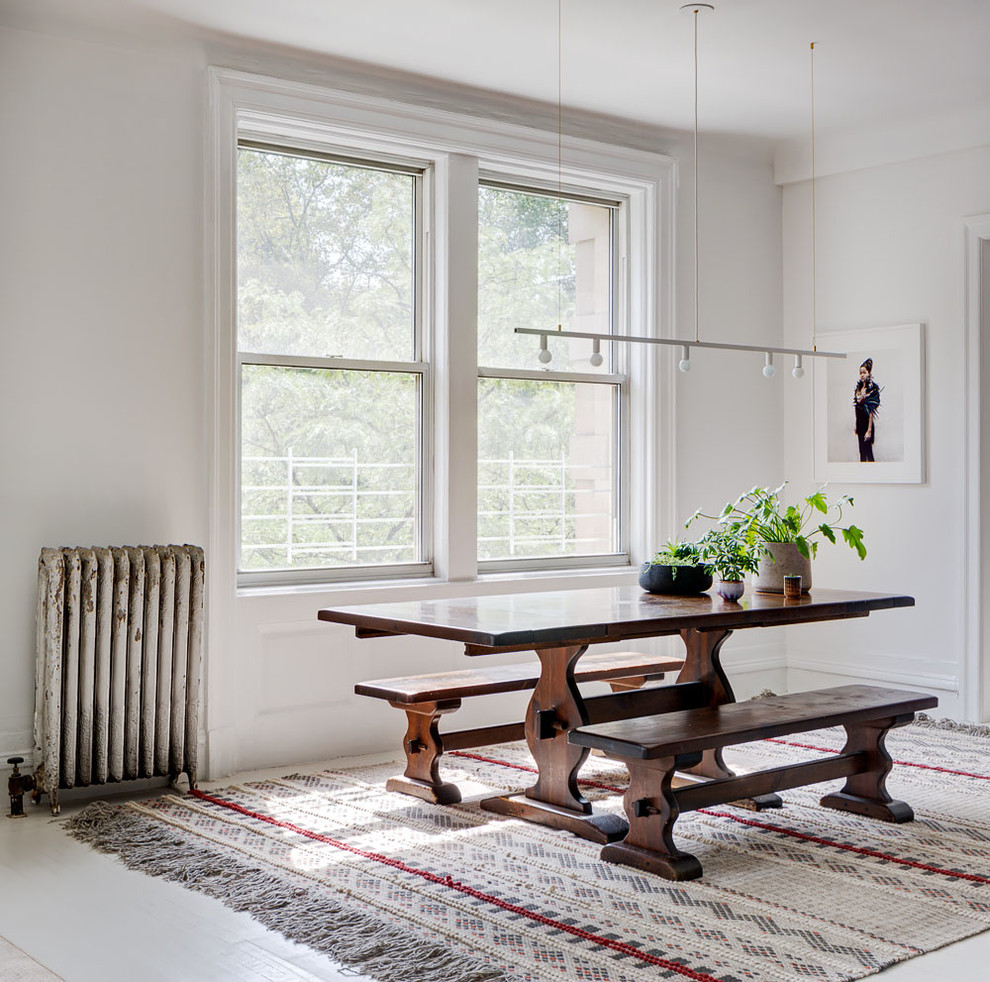 Transitional kitchen/dining combo in New York with white walls, painted wood floors and white floor.