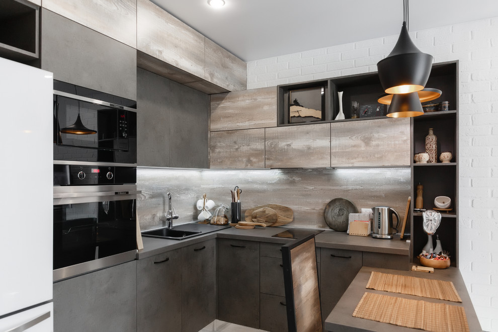 This is an example of a small industrial u-shaped separate kitchen in Moscow with a drop-in sink, flat-panel cabinets, grey cabinets, wood benchtops, brown splashback, timber splashback, stainless steel appliances, laminate floors, with island, grey floor and brown benchtop.