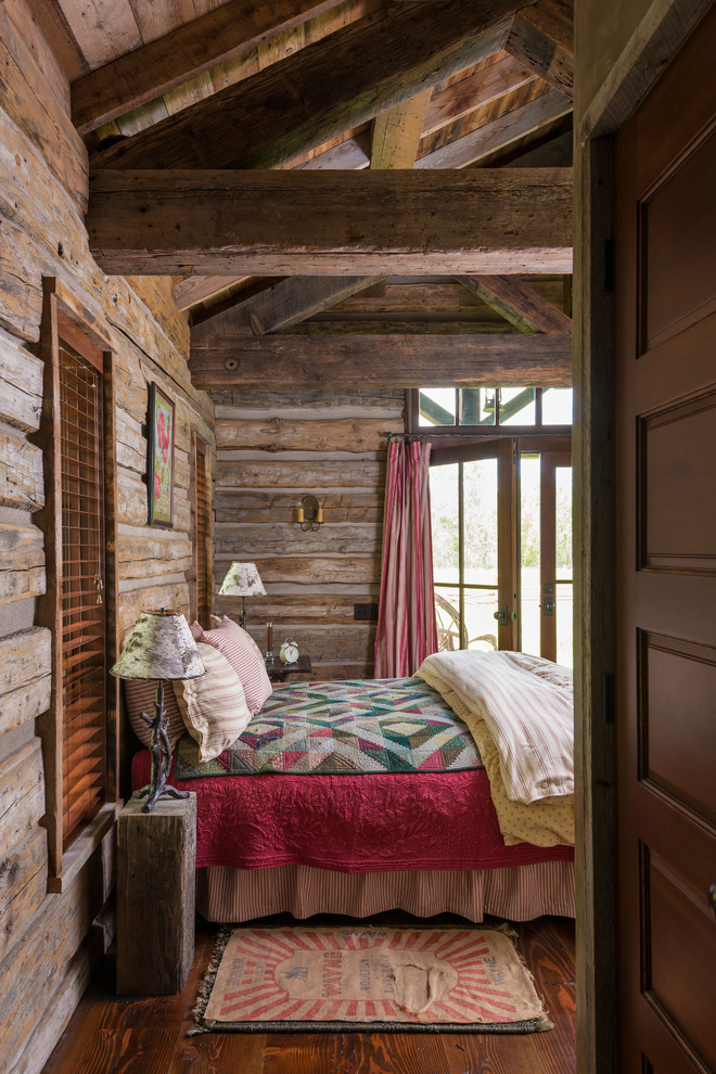 This is an example of a country bedroom in Other with brown walls and dark hardwood floors.