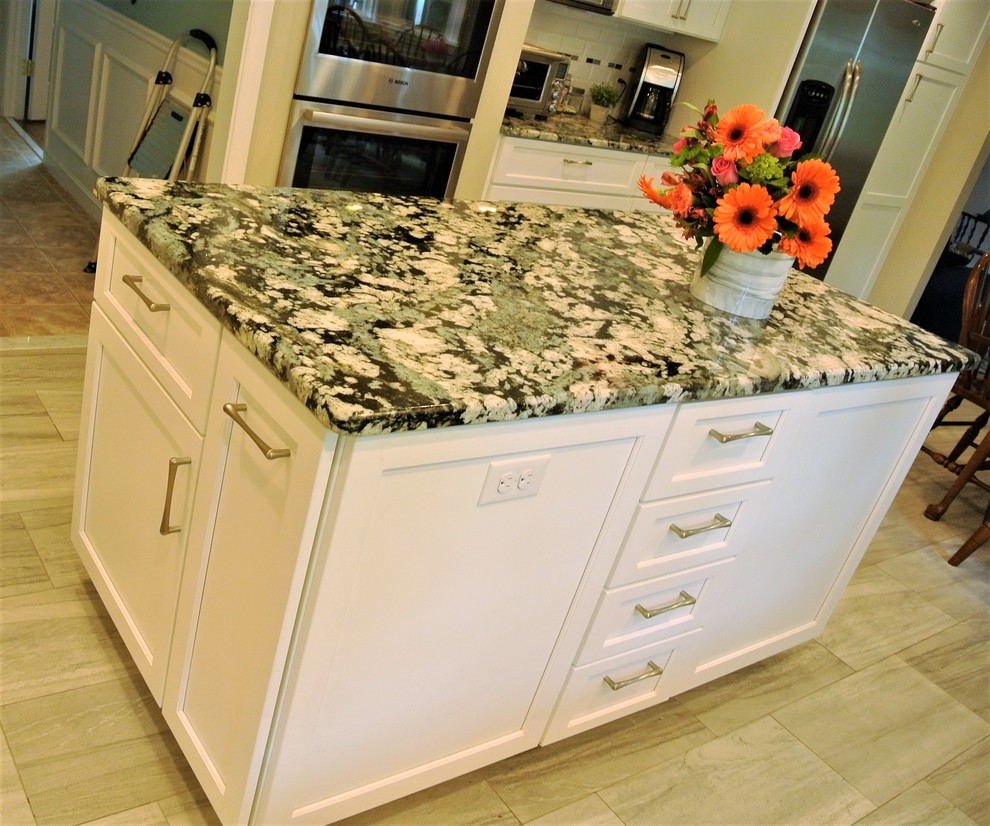 Kitchen - transitional kitchen idea in Boston with an undermount sink, shaker cabinets, granite countertops, subway tile backsplash, stainless steel appliances and an island