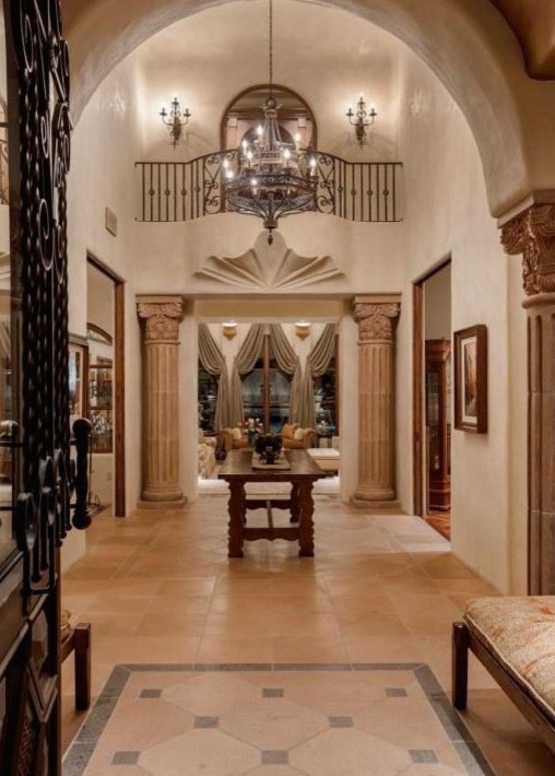 Foyer - huge travertine floor foyer idea in Phoenix with beige walls and a metal front door