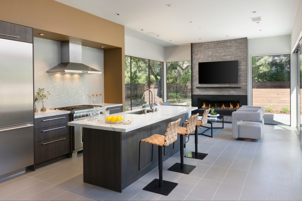Contemporary galley kitchen in Orange County with an undermount sink, flat-panel cabinets, dark wood cabinets, white splashback, matchstick tile splashback, stainless steel appliances, with island, grey floor and white benchtop.